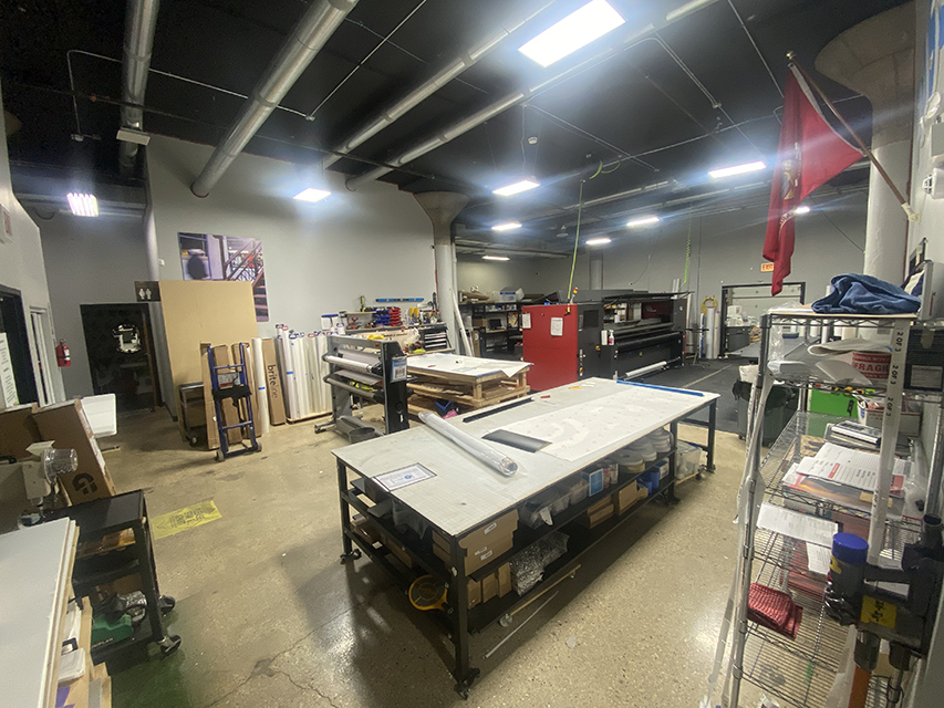 Print shop with vinyl rolls and large-format printers.